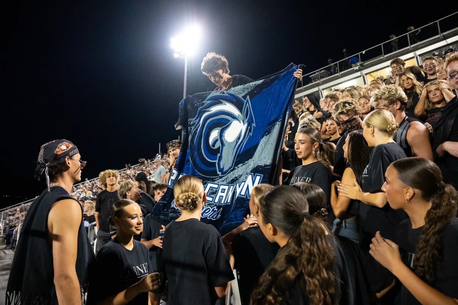 Fans in the stands wrapped in custom fundraiser blankets