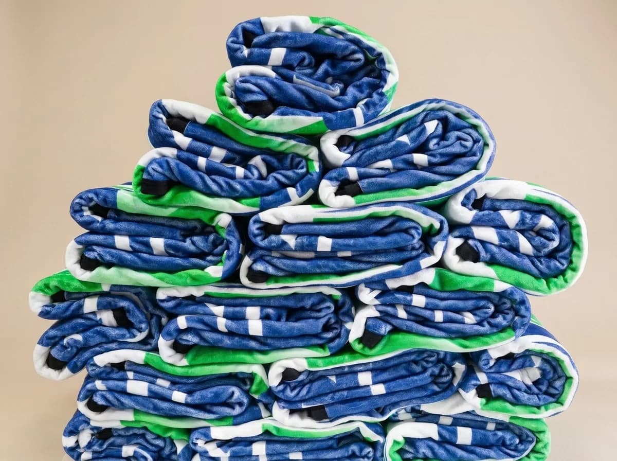 A stack of folded custom blankets ready for handout day